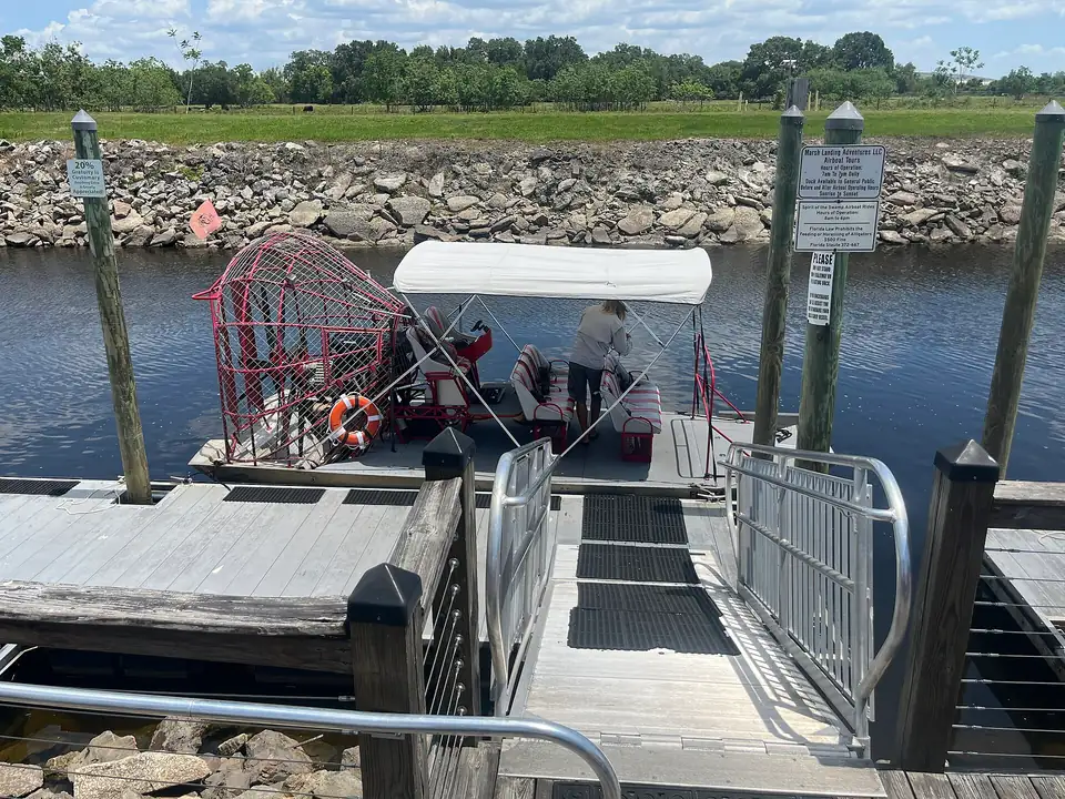 An airboat tied up on the St. Cloud canal under a wide Florida sky